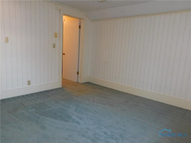 carpeted empty room with vaulted ceiling and wallpapered walls