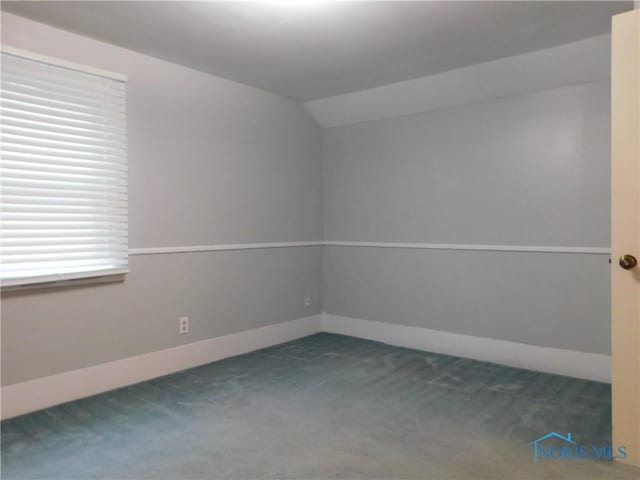 unfurnished room featuring carpet flooring and lofted ceiling