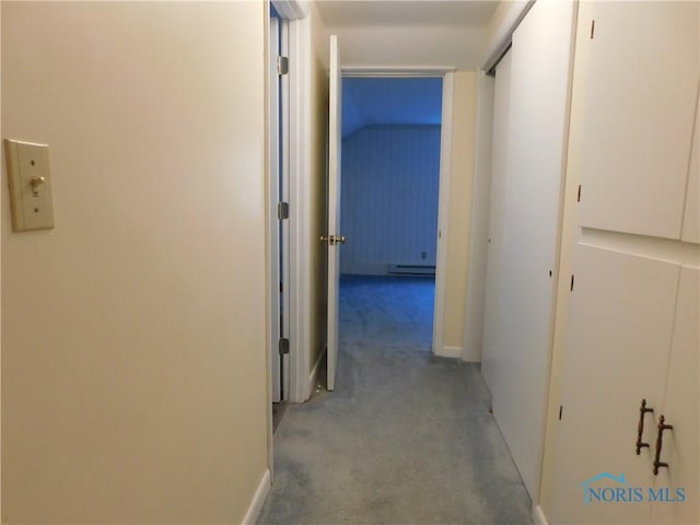 hall with a baseboard heating unit, carpet flooring, and baseboards