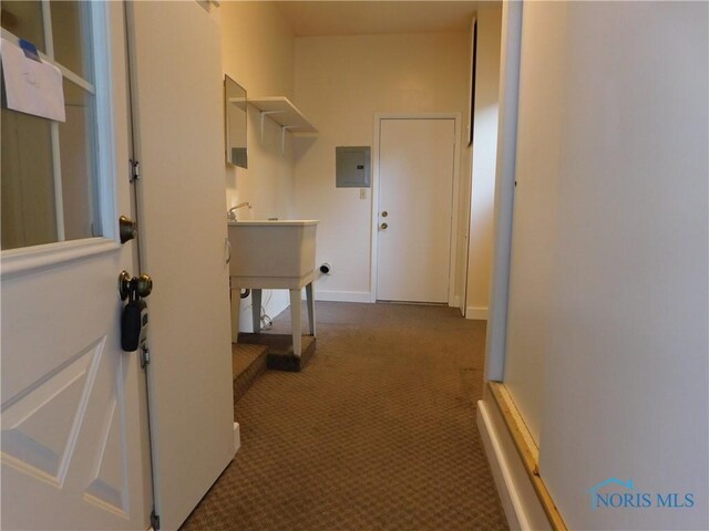 hallway with dark colored carpet and electric panel