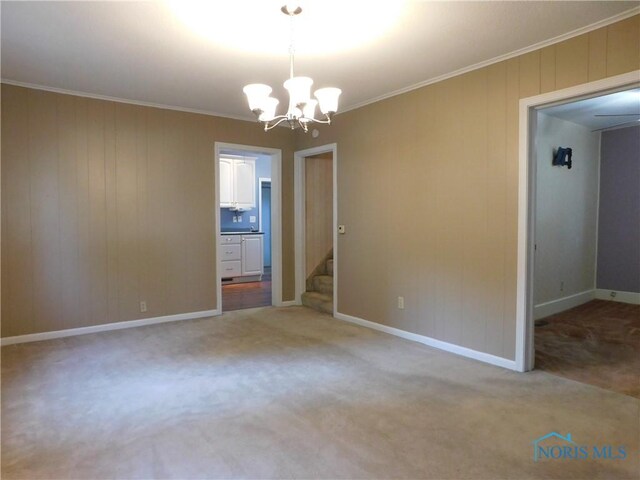 interior space with light colored carpet, a chandelier, and ornamental molding