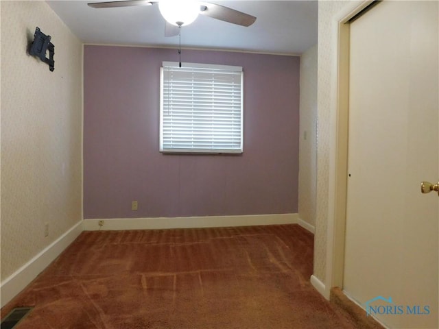 empty room with visible vents, baseboards, a ceiling fan, and carpet flooring