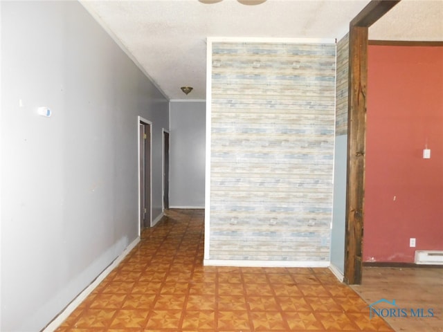 hallway with a baseboard radiator, parquet floors, and a textured ceiling