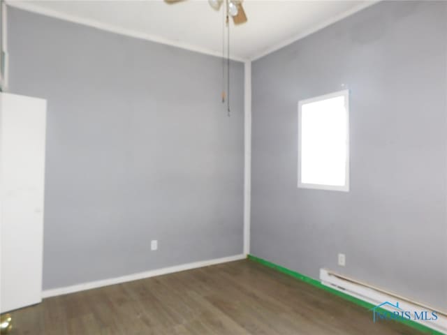 unfurnished room with ceiling fan, a baseboard heating unit, and wood-type flooring