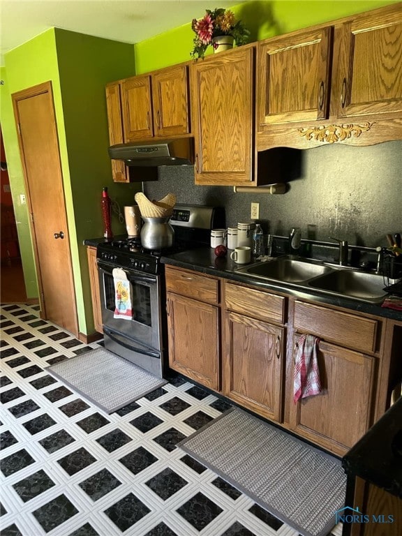 kitchen with sink, stainless steel range, and light tile patterned floors