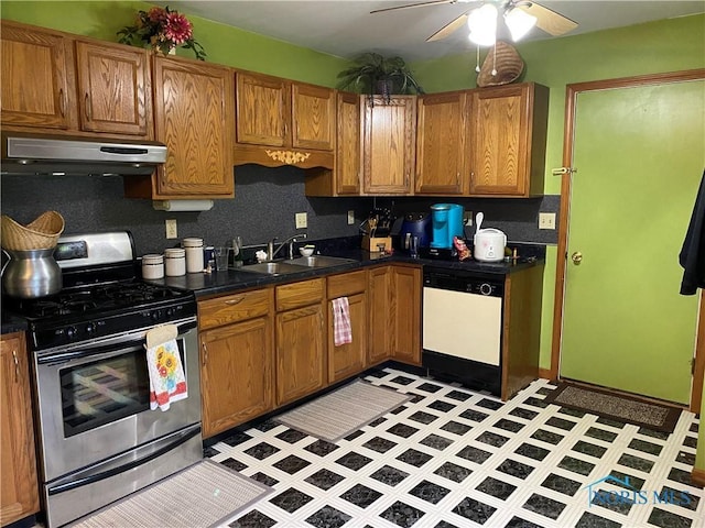 kitchen with dark countertops, under cabinet range hood, gas range, dishwasher, and a sink