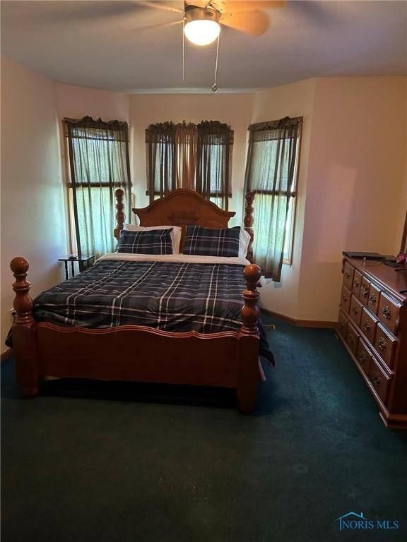 carpeted bedroom with ceiling fan and baseboards