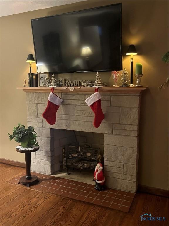 details featuring hardwood / wood-style flooring and a stone fireplace