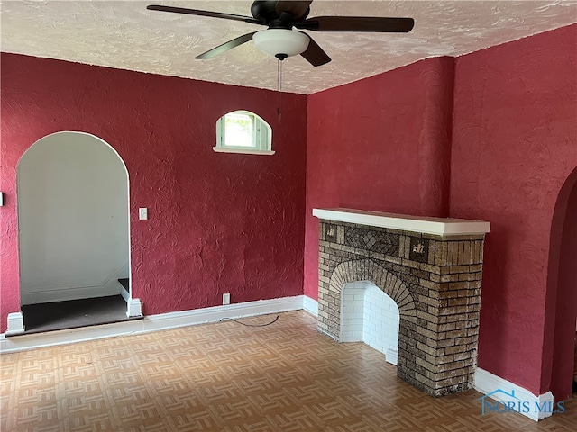 unfurnished living room with a textured ceiling, ceiling fan, and parquet flooring