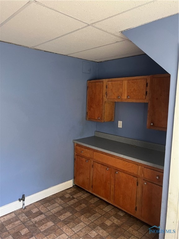 kitchen featuring dark tile patterned flooring and a paneled ceiling