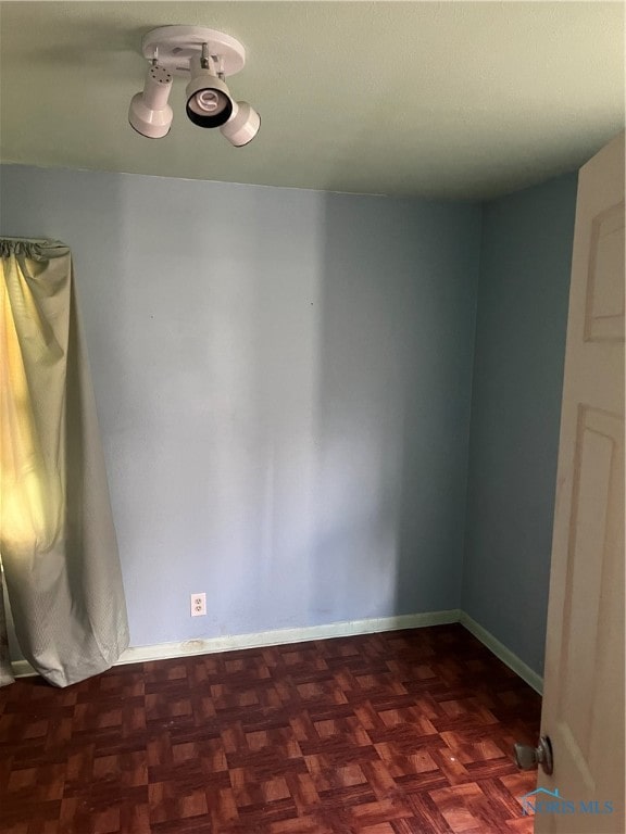 spare room featuring dark parquet floors