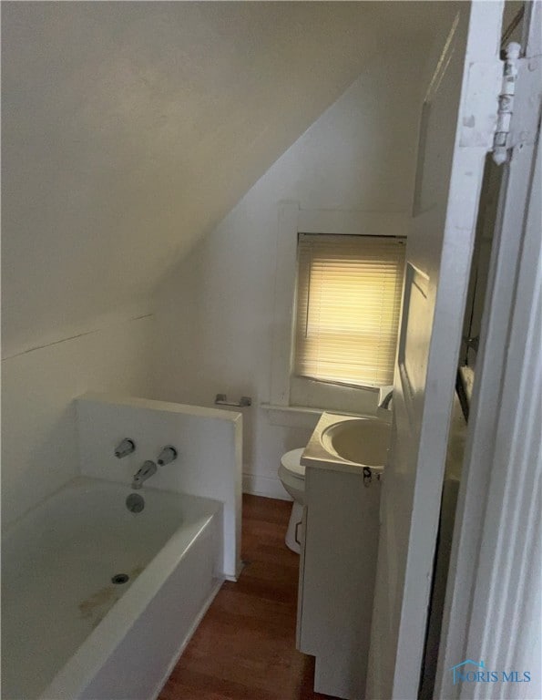 bathroom featuring toilet, vanity, lofted ceiling, and wood-type flooring