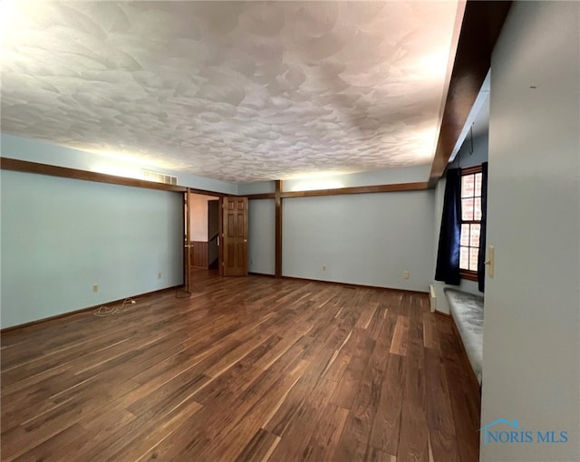 basement with dark wood-type flooring and a textured ceiling