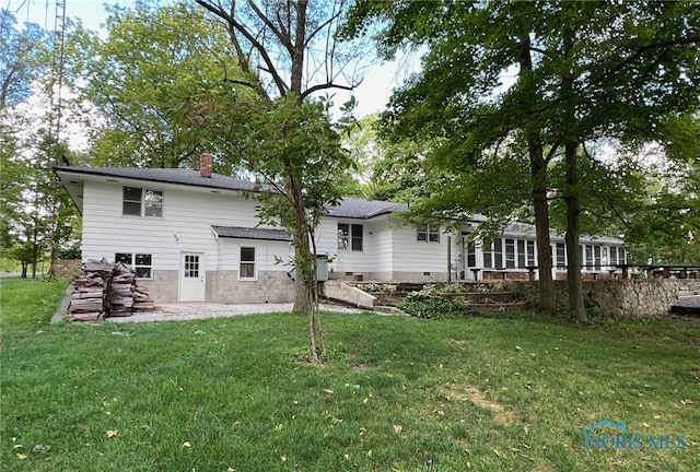 rear view of property with a patio and a lawn