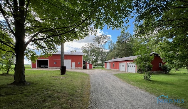 view of front of home featuring an outbuilding, a garage, and a front yard