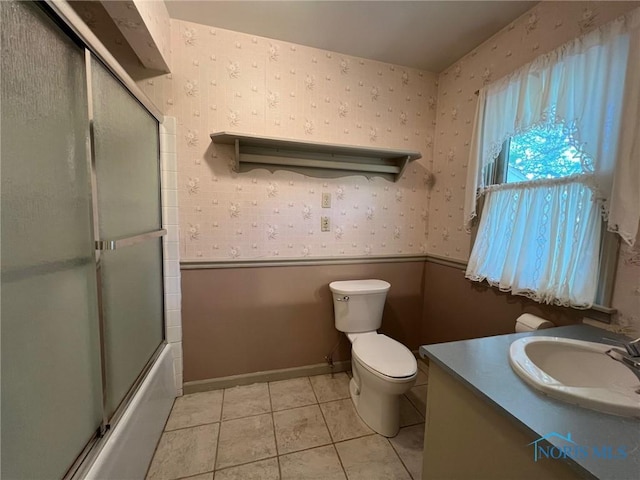 full bathroom featuring vanity, tile patterned floors, shower / bath combination with glass door, and toilet