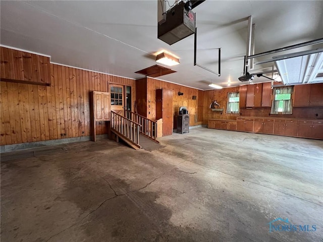 garage featuring a garage door opener and wood walls