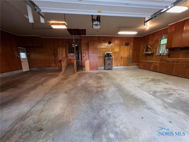 garage with a garage door opener and wood walls