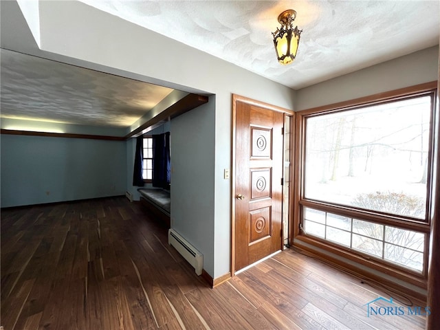 foyer entrance with a baseboard radiator, a textured ceiling, and dark hardwood / wood-style flooring