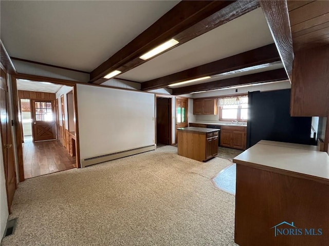 kitchen featuring light carpet, a baseboard heating unit, beamed ceiling, and black fridge