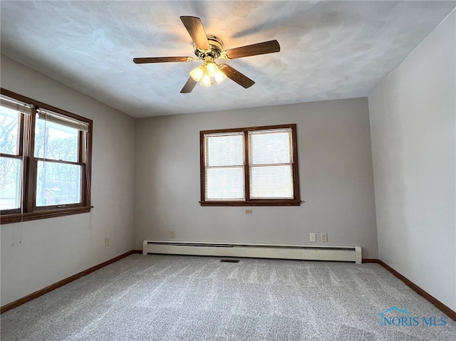 empty room with ceiling fan, baseboard heating, and carpet flooring