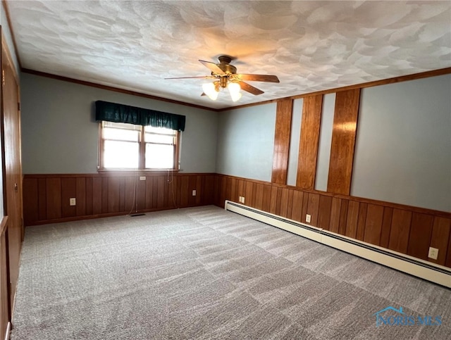 spare room with crown molding, a baseboard radiator, a textured ceiling, and carpet flooring