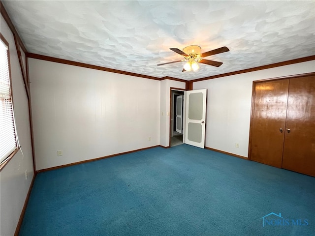 unfurnished bedroom with ceiling fan, ornamental molding, carpet, and a closet