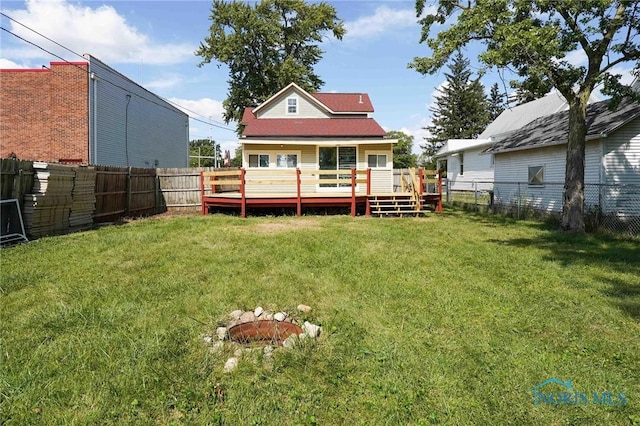 back of property featuring a deck and a lawn