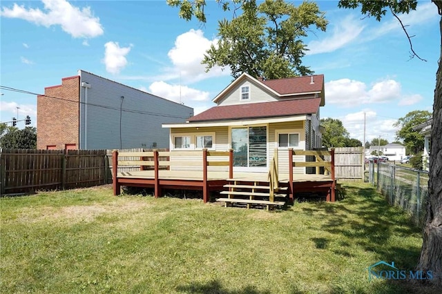 rear view of property featuring a lawn and a deck