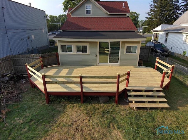 back of property featuring a lawn and a deck