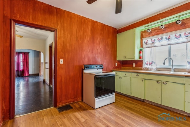 kitchen featuring electric range, ceiling fan, sink, and light hardwood / wood-style flooring