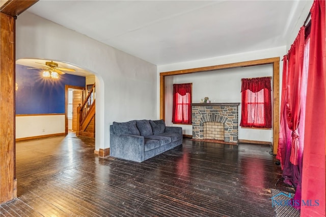 living room featuring hardwood / wood-style floors, ceiling fan, and a fireplace