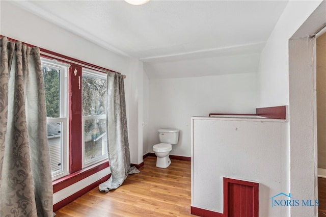 bathroom featuring hardwood / wood-style floors, toilet, and vaulted ceiling