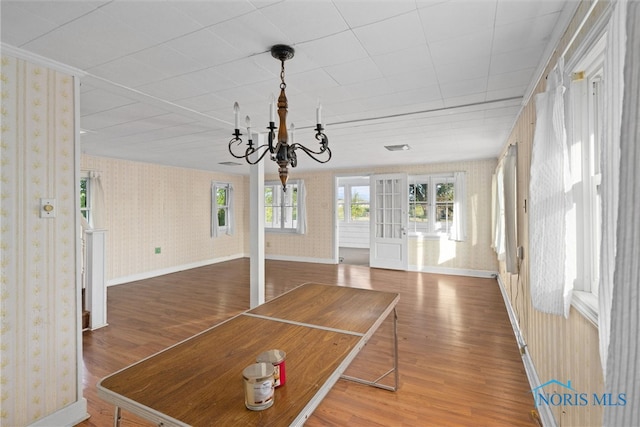 unfurnished dining area with hardwood / wood-style floors and a chandelier