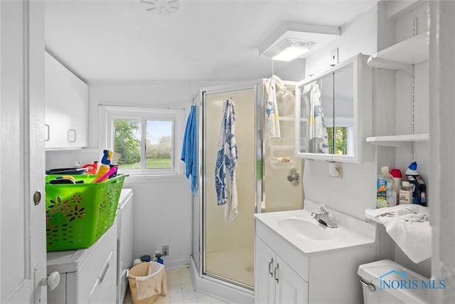 bathroom with tile patterned floors, toilet, vanity, and a shower with shower door