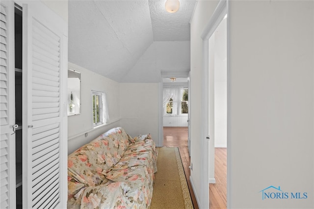 sitting room featuring a textured ceiling, vaulted ceiling, and hardwood / wood-style flooring