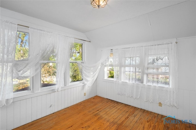 unfurnished sunroom featuring vaulted ceiling and a healthy amount of sunlight