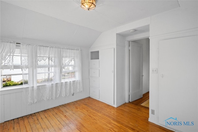 interior space with light hardwood / wood-style floors and lofted ceiling