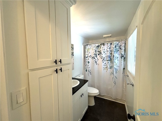 bathroom with tile patterned flooring, curtained shower, vanity, and toilet