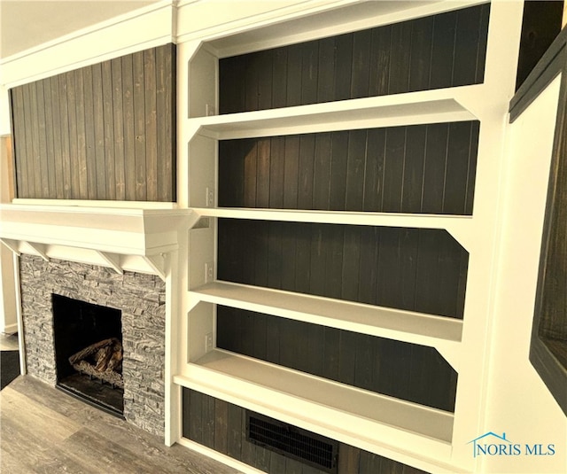 interior details with hardwood / wood-style flooring and a stone fireplace