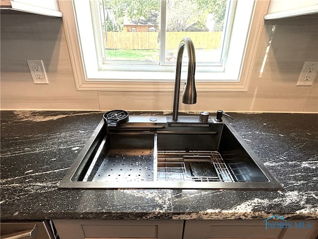 room details featuring sink and dark stone countertops