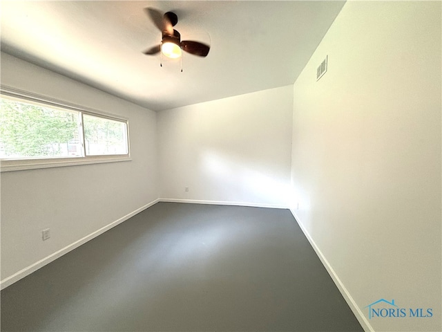 spare room with ceiling fan and concrete floors