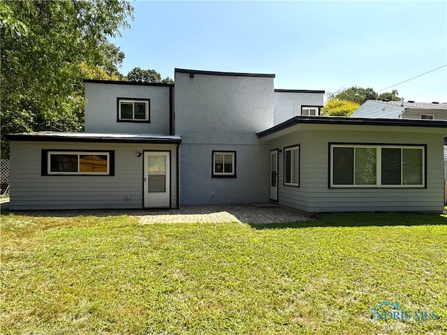 back of house featuring a lawn