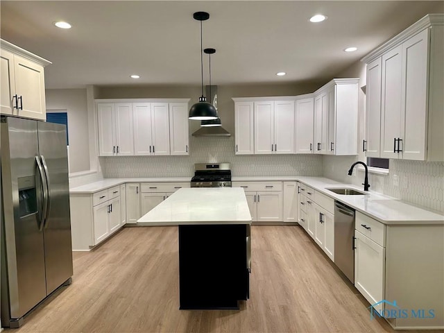 kitchen with white cabinetry, sink, hanging light fixtures, a center island, and stainless steel appliances