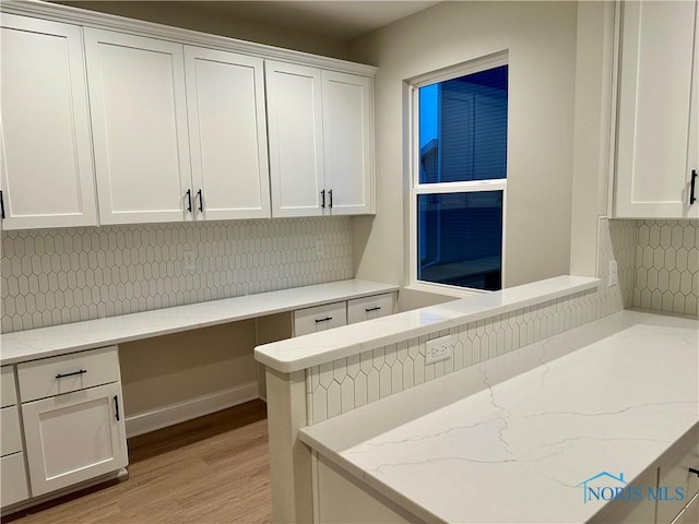 clothes washing area with light hardwood / wood-style flooring