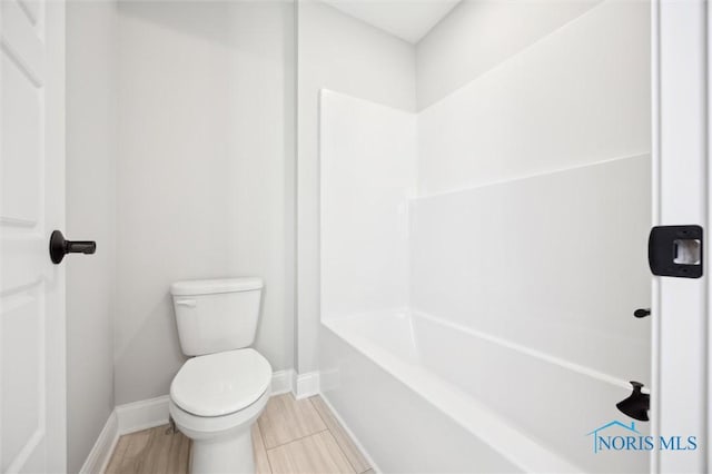 bathroom featuring toilet and baseboards