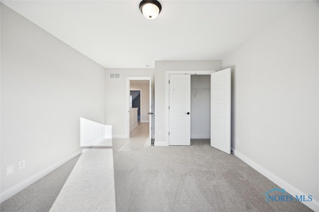 unfurnished bedroom featuring a closet, visible vents, baseboards, and carpet