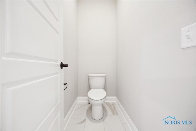 bathroom featuring toilet, baseboards, and marble finish floor