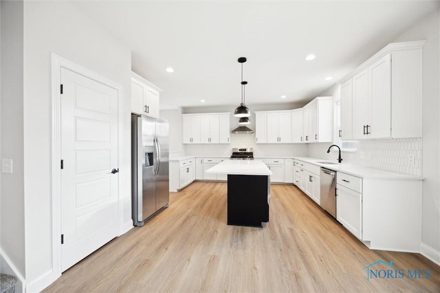 kitchen featuring tasteful backsplash, a kitchen island, appliances with stainless steel finishes, white cabinets, and light countertops