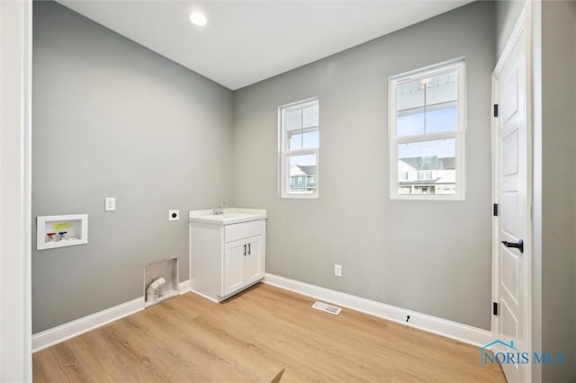 clothes washing area featuring visible vents, washer hookup, light wood-style floors, baseboards, and hookup for an electric dryer